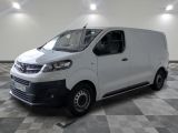 la camionnette blanche est garée dans une grande pièce au sol en damier