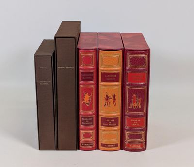 trois livres superposés sur une surface blanche