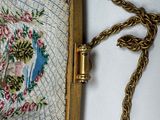 a purse with a floral design on it on a chain