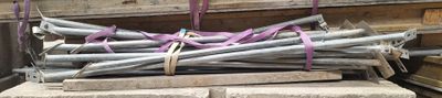 un tas de barres d'acier posé sur un tas de bois