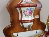 a wall mounted shelf with a vase and other items on it