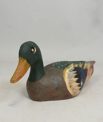 a wooden duck that is sitting on a white surface