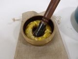 a small bowl with a wooden stick inside of it