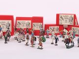 de nombreuses figurines représentant des personnes debout devant une boîte rouge