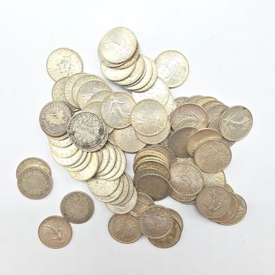 un tas de pièces de monnaie posées sur une surface blanche, sur fond blanc