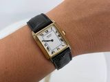 an image of a woman ' s wrist with a watch on it