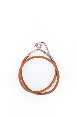 un gros plan sur une paire de bracelets en cuir sur fond blanc