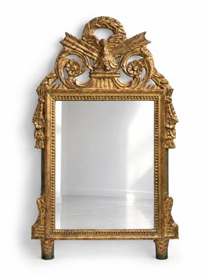 an ornate gold mirror with a bird on top of it