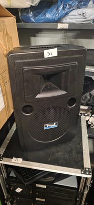 une enceinte noire posée sur un meuble dans une pièce