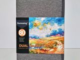 a close up of a gray notebook with a painting on it