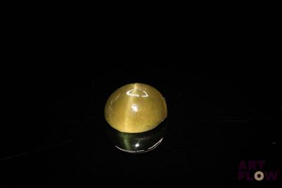 a yellow apple sitting on a black surface