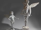 deux statues représentant un garçon et une fille debout l'un à côté de l'autre