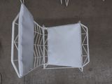 a white chair that has a white cushion on top of it