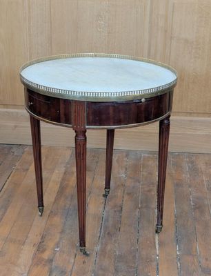 une petite table avec un plateau en marbre sur un plancher en bois