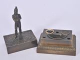 a small statue of a man standing next to a small box