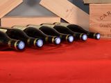 several bottles of wine are lined up on a red table cloth
