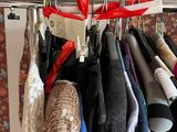 a lot of clothes hanging on a rack in a room