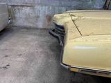 two old cars parked next to each other in a garage