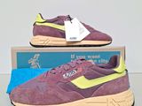 a pair of purple and yellow sneakers on a blue box