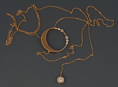 un collier en or orné d'un croissant et d'un pendentif en diamant, monté sur une chaîne