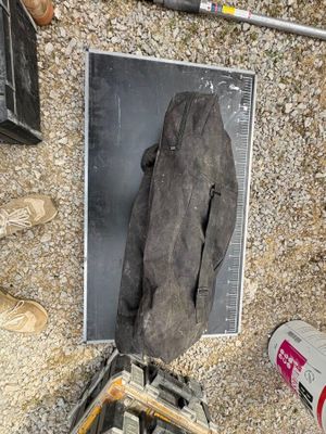 une photo d'un morceau de métal posé par terre à côté d'une paire de chaussures