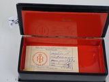 a black box with a red lid that has a ticket inside of it