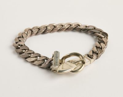 un gros plan sur un bracelet à chaîne en argent muni d'un fermoir