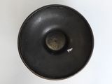 a black bowl with a white arrow on it