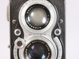 a close up of an old camera on a white surface