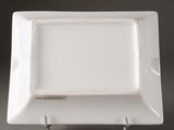 a close up of a white square plate on a metal stand