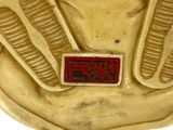 a gold statue of an egyptian woman with a red label on it