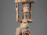 a wooden statue of a man with a hat on his head