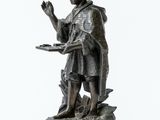 a statue of a man holding a tray of food