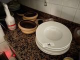many plates and bowls on the counter in the kitchen