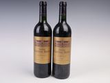 deux bouteilles de vin posées l'une à côté de l'autre sur une surface blanche