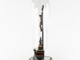 a statue of jesus on the cross under a glass dome