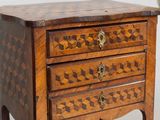 a small wooden chest of drawers on a stand