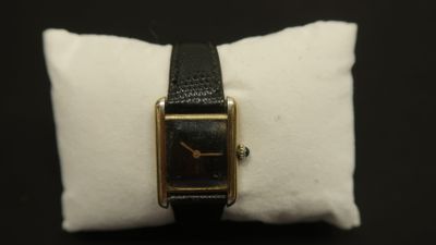an image of a black and gold watch on a white pillow