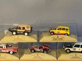 six toy cars in a display case on a table