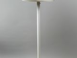 une lampe de table blanche avec un pied blanc sur un fond gris