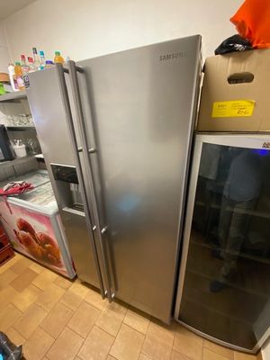 a refrigerator and freezer in a kitchen with boxes on the floor