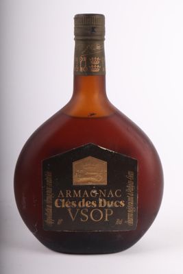une photo d'une bouteille de brandy posée sur une surface blanche