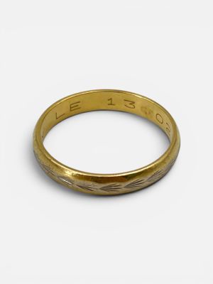 a close up of a gold ring on a white surface