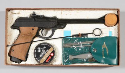 une boîte contenant un pistolet, des ciseaux et d'autres objets