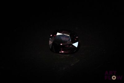 un diamant violet foncé sur une surface noire