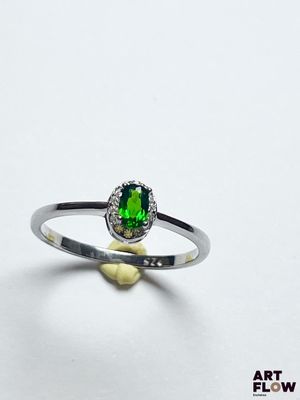 Gros plan sur une bague ornée d'une pierre verte