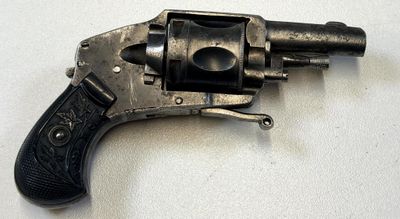 un vieux revolver avec une crosse noire sur un fond blanc