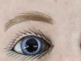 a close up of a doll ' s face with blue eyes