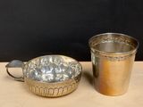 a silver cup next to a silver cup on a table