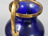 a blue vase with a gold handle on a table